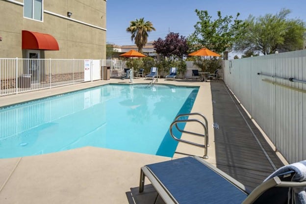 The Best Western Plus Henderson pool is the centerpiece of this image, while loungers with complimentary pool towels are in the distance.