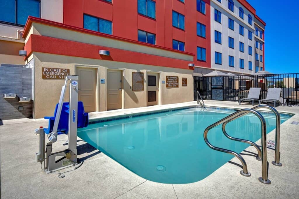 Hotel pool with mobility lift showing in the foreground.