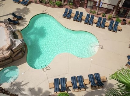 Aerial view of hotel pool with blue loungers around the pool deck.