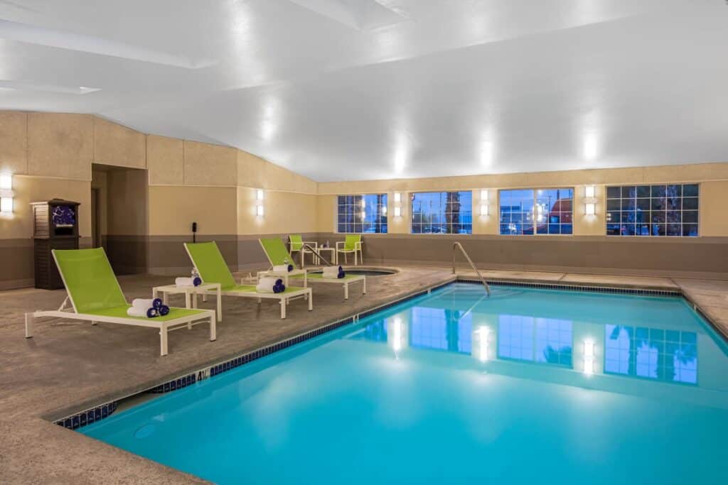 Hotel indoor pool with loungers on the left hand side.