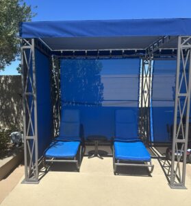 Blue walls and roof of a Polo Towers pool cabana. a Pair of blue loungers are inside the cabana.