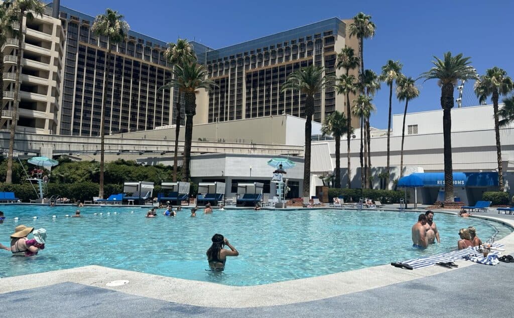 A guest enjoys cooling off in the pool.  The main hotel building is in the background.