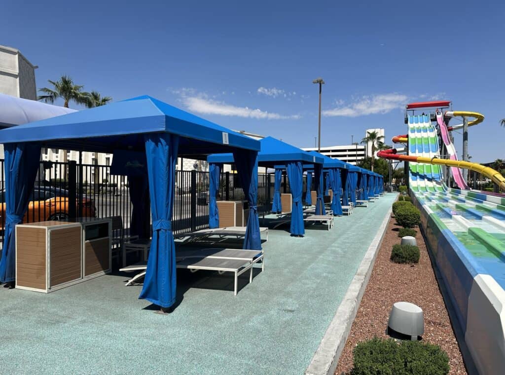 Blue fabric cabanas  are in a line near the giant waterslide. 