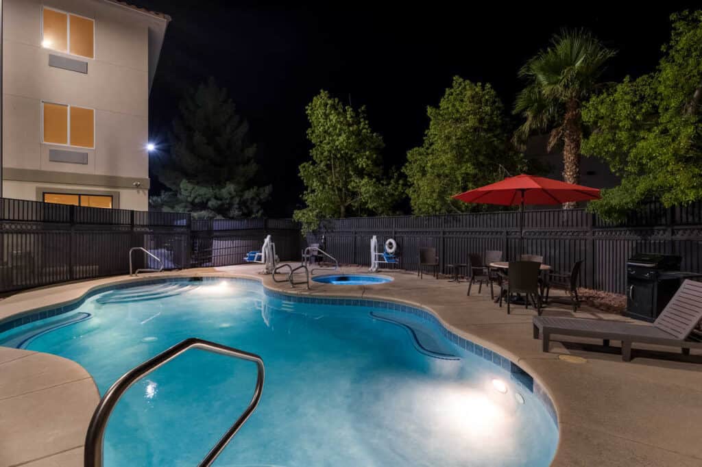 Night time view of pool. Hot tub can be seen in the background.