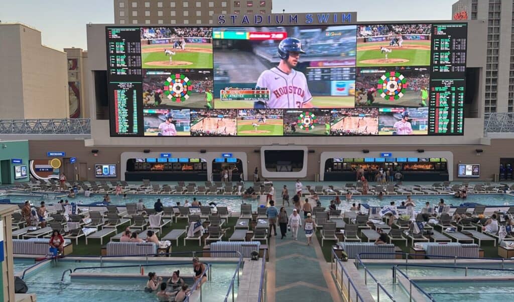Baseball shown on the giant screen while guests enjoy the pool deck.