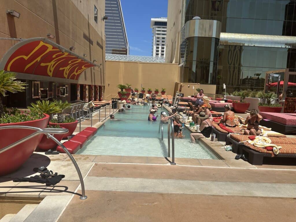 Guests in the Hideout Pool and relaxing on pool deck loungers.