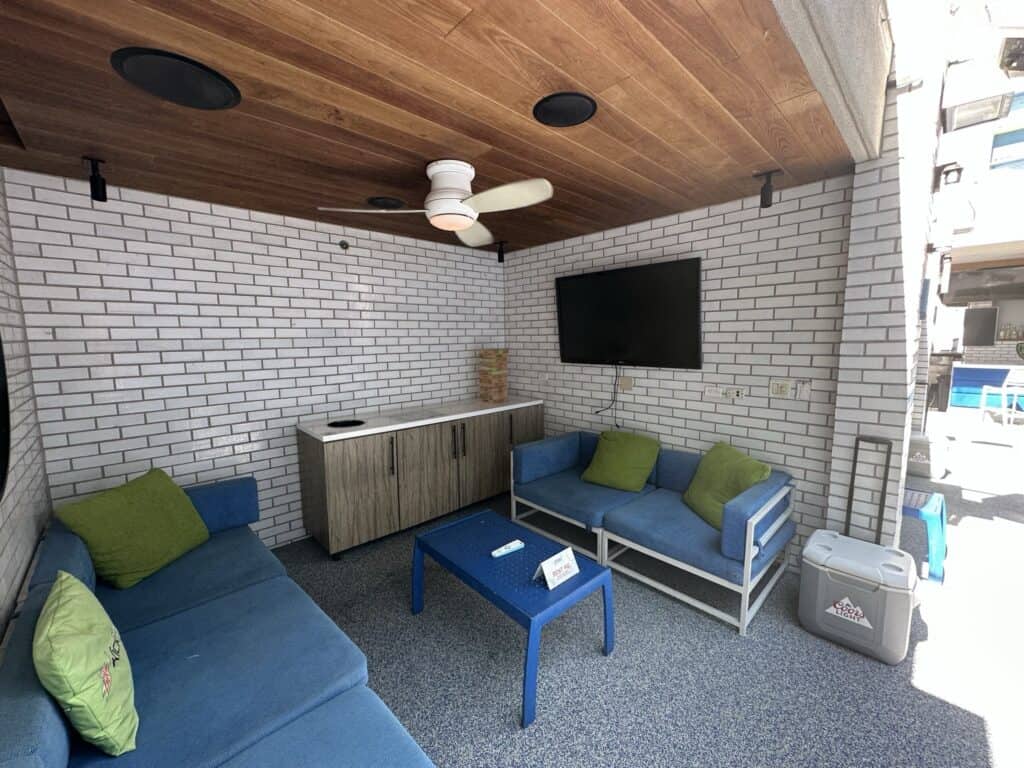 Inside a Linq Cabana you see blue seating, storage and a mounted TV.