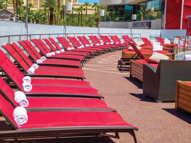 Red loungers with white pool towels placed on each lounger.