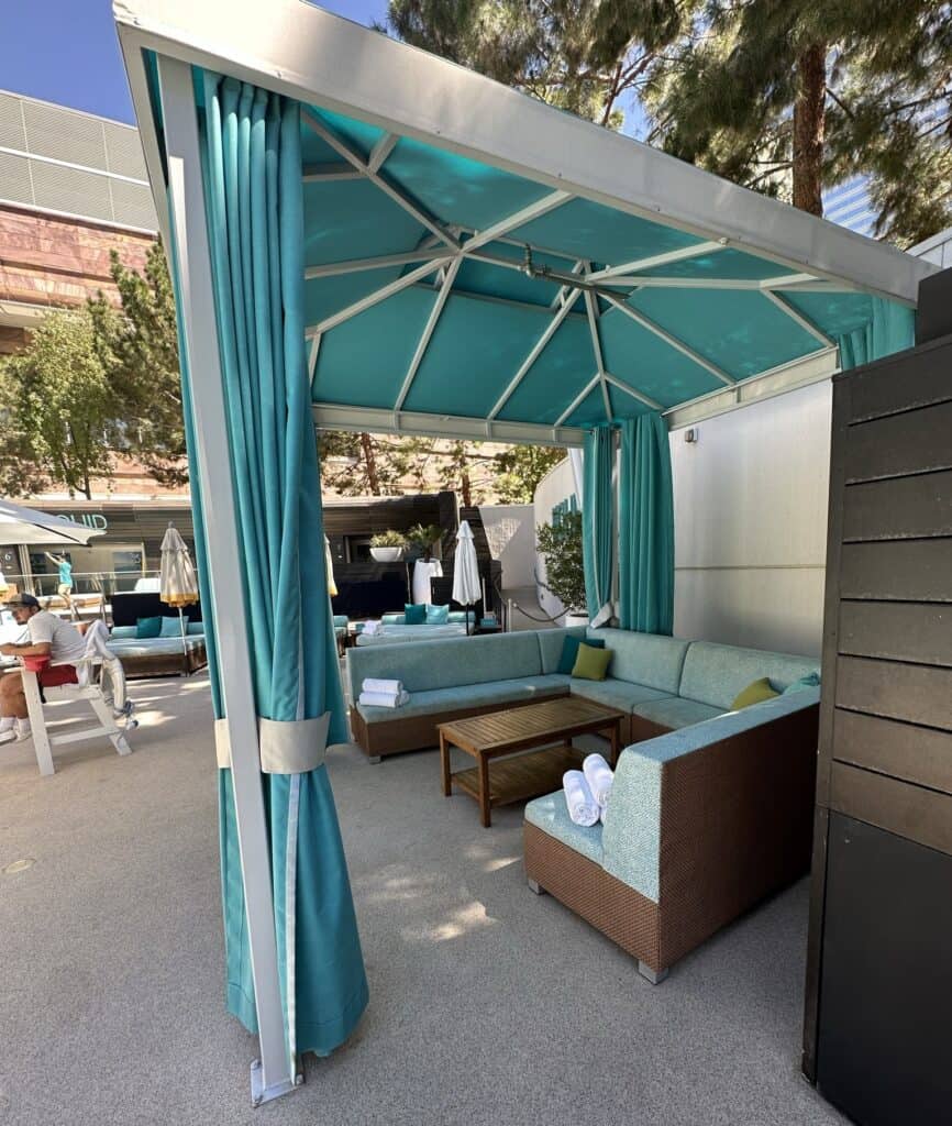 Blue cabana with sides open.  Sectional couch and table are in the cabana.