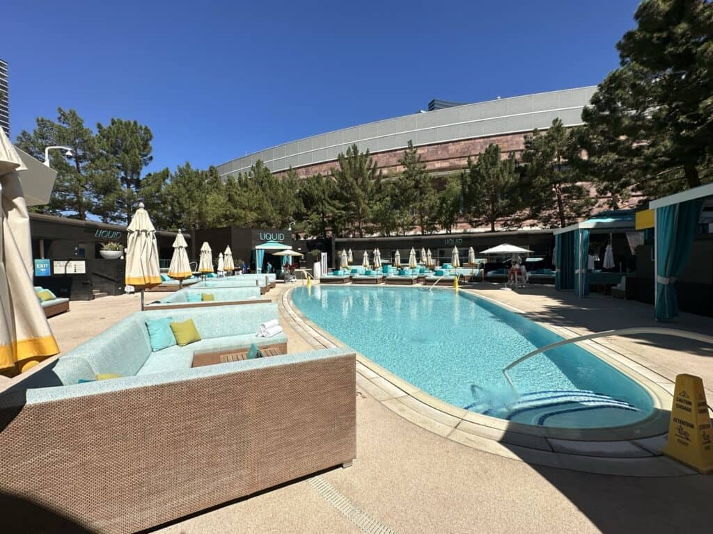 Pool at opening time with no guests in it.  Light Blue daybeds are located around the pool.